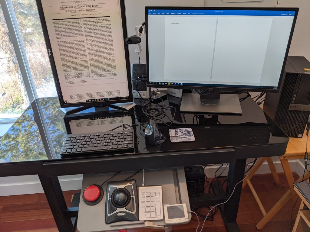 Lisa's computer set up, showing two monitors, keyboards and other input devices